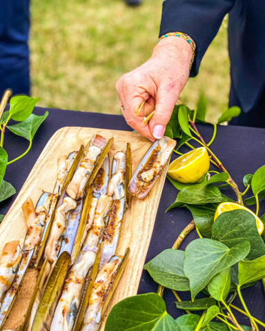 Navajas cocinadas al fuego en Ofyr, glaseadas con mirin y mostaza, presentadas de manera elegante para un evento gourmet.