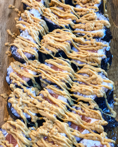 Makis de salmón presentados de forma elegante en una bandeja gourmet, listos para servir en un evento.