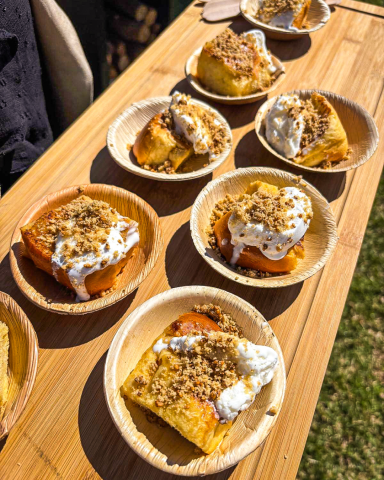 Torrija servida con helado de leche merengada y crumble de almendras, presentada de manera elegante para un evento gourmet.